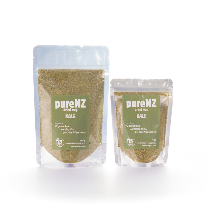 Two bags of PureNZ dried kale powder, one larger and one smaller, with green labels indicating the product name and weight.